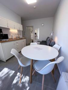 福纽德Lujza Apartman的厨房配有白色的桌子和白色的椅子