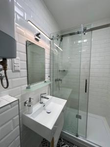 福纽德Lujza Apartman的一间带水槽和玻璃淋浴的浴室