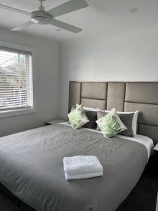 Chittaway PointLakeview House LILAC的一间卧室配有一张大床,上面有白色毛巾