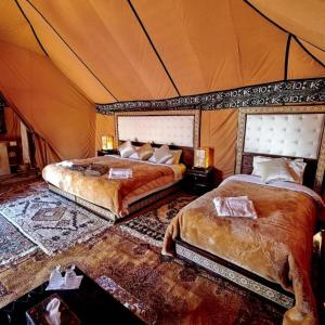 梅尔祖卡Desert Lover's Luxury Camp的一间帐篷内带两张床的卧室