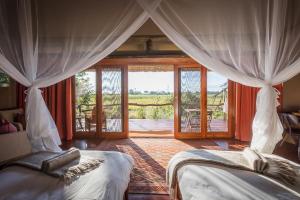 Okavango DeltaAmber River Camp的一间卧室设有两张床,享有庭院的景色