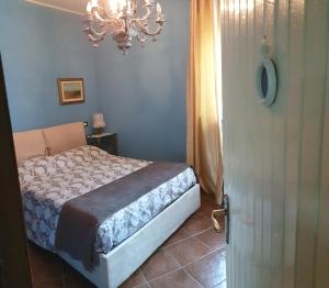 GatticoB&B Villa Giardini Susanna的一间卧室配有一张床和一个吊灯