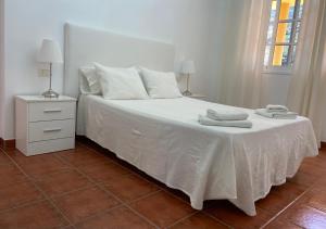 弗龙特拉VV La Escondida的卧室配有白色床和毛巾