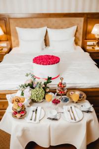 伊万诺-弗兰科夫斯克纳迪亚酒店的床上的桌子,上面摆放着食物和鲜花