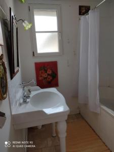 洛特河畔卡斯泰尔莫龙Lulu的白色的浴室设有水槽和窗户。