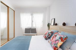 阿尔卡拉Home2Book Stylish Apartment Alcalá Beach的一间卧室配有一张带蓝色枕头的大床