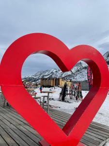 帕苏德尔托纳莱米拉蒙缇大酒店的滑雪小屋顶部的红色心雕塑