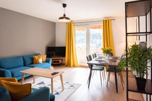 方黛涅Les chambres du Vercors - Parking Free Fibre Netflix的客厅配有蓝色的沙发和桌子