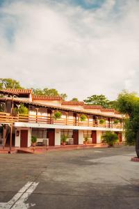 库库塔Hotel Faranda Bolivar Cucuta, a member of Radisson Individuals的一座红色和白色的建筑,设有停车场