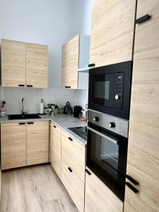 布鲁塞尔Superbe logement près de Bruxelles avec spa privé的厨房配有木制橱柜和黑微波炉