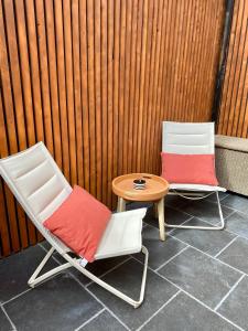 布鲁塞尔Superbe logement près de Bruxelles avec spa privé的围栏旁的两把椅子和一张桌子
