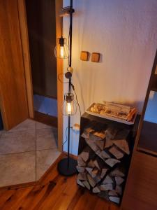 马汀Martin´s House的一间房间,配有一盏灯和一堆木柴