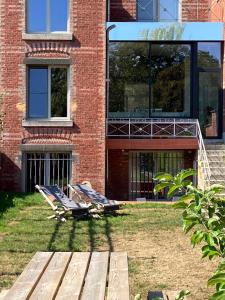 那慕尔Maison Henri Namur的大楼前草地上的两把躺椅