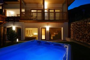 拉伊翁阿尔平风格酒店的夜晚在房子前面的一个蓝色泳池