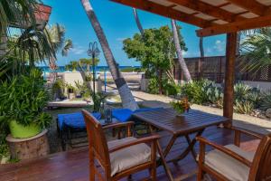 棕榈滩阿鲁巴日落海滩一室公寓酒店的一个带木桌和椅子的海滩庭院