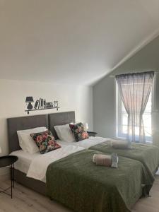 贝尔格莱德MiniCity的一间卧室设有两张带绿床单的床和窗户。