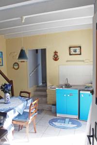 Saint-Vincent-SterlangesChez Martine et Bernard的厨房配有蓝色橱柜和带水槽的桌子