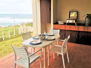 乌旺戈海滩Laguna La Crete 28的阳台上配有白色的桌椅,享有海景