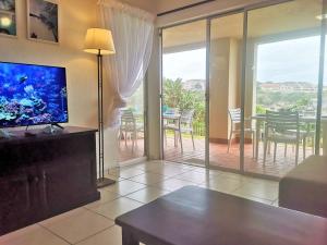 乌旺戈海滩Laguna La Crete 28的一间带电视和餐桌的客厅以及一间用餐室