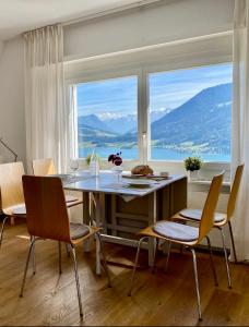OberägeriBeautiful apartment with fantastic views的一间带桌椅和大窗户的用餐室