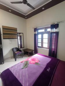 瑞诗凯诗Nature Villa的一间卧室配有一张紫色床,床上有鲜花
