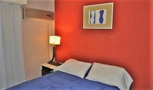 科尔多瓦科多巴公寓的一间卧室设有红色墙壁、一张床和一盏灯