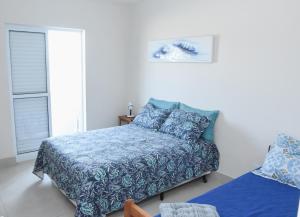 桑托斯Verdadeiro pé na areia TOP的一间卧室配有一张带蓝色毯子的床