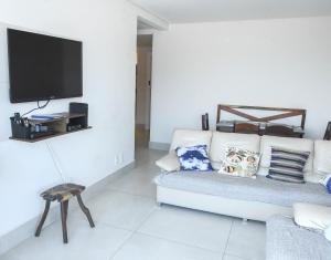 桑托斯Verdadeiro pé na areia TOP的客厅配有白色沙发和电视