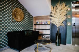 圣马尔Cottages de France CDG的客厅配有黑色沙发和植物花瓶