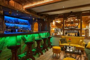 采尔马特Jägerhof Serviced Apartements的酒吧餐厅,酒吧,酒吧,有绿色的酒吧凳子
