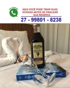 瓜拉派瑞Magnífico APARTAMENTO de Charme - 3 quartos AR CONDICIONADOS SPLIT - Beira Mar, 2 banheiros, 2 vagas garagem, 4 varandas, 2 elevadores, Redes para descanso, Wi-Fi, Air Fryer, Disney Plus, Star Plus, HBO Max, Guarda Sol, Cadeiras de Praia e Caixa Térmica的床上的天鹅酒和玻璃杯