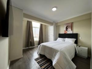 CarazDepartamentos Caraz的卧室设有一张白色大床和一扇窗户。