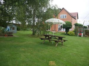 切尔滕纳姆Cheltenham accommodation -self-catering-2 bedrooms的院子里带雨伞的野餐桌