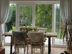 切尔滕纳姆Cheltenham accommodation -self-catering-2 bedrooms的餐桌、椅子和大窗户