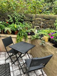 海伯敦桥Stunning 2 bed in the heart of hebden bridge的种有植物的庭院里的桌椅