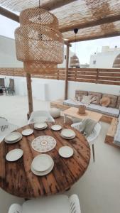 科拉雷侯NOMAD SURF HOUSE的一张带白色板子和椅子的木桌