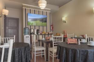 圣胡安讷沃苏左酒店的用餐室配有2张桌子和1张桌子及椅子