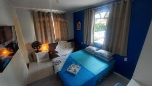 伊达贾伊Suíte Azul com SmartTv, Cama Queen e Banheiro Privativo的蓝色的客厅配有沙发和窗户