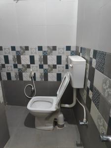 迈索尔Mysore Studio Rooms的浴室设有卫生间,墙上铺有瓷砖。