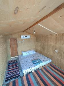 努韦巴Sinai Life Beach Camp的一张位于带木制天花板的客房内的大床
