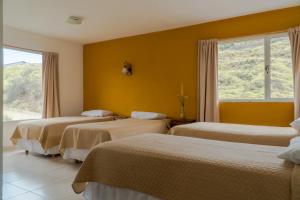 厄尔查尔坦Hosteria Alma de Patagonia的酒店客房设有三张床和窗户。