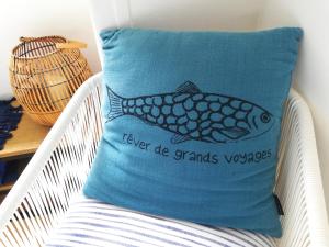 坎佩尔Sweet home en plein coeur de Quimper的枕头上摆着鱼,坐在椅子上