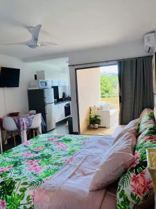 帕皮提Tehautahi Cozy Lodge的一间带大床的卧室和一间厨房
