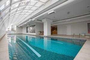 库里提巴QOYA Hotel Curitiba, Curio Collection by Hilton的一个带玻璃天花板的大型游泳池