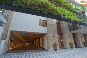 库里提巴QOYA Hotel Curitiba, Curio Collection by Hilton的一座植物在建筑的一侧