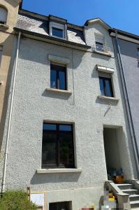 卢森堡Nice rooms in Beggen house - In Luxembourg city的白色的建筑,窗户在建筑的一侧