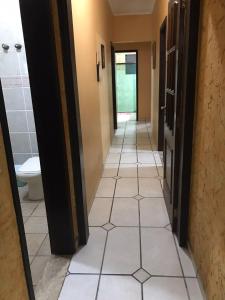 佩鲁伊比Nova ADM - Hostel Pérolas de Peruíbe的走廊上设有带卫生间的浴室,铺有瓷砖地板。