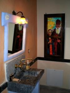 卡拉利特斯佩特拉迪1873旅馆的一间带水槽的浴室和墙上的绘画