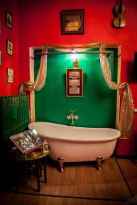 瓦雷泽奥兹共和国客房旅馆的绿色浴室设有白色浴缸和桌子