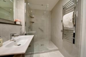 贝尔法斯特TALLEST BUILDING IN THE CITY CENTRE SLEEPS 5 incredible city mountain and Lagan views的白色的浴室设有水槽和淋浴。